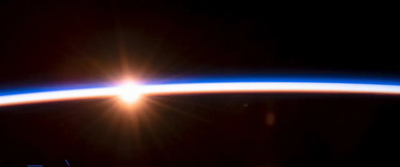 O sol nascendo no limbo da Terra, visto do espaço.