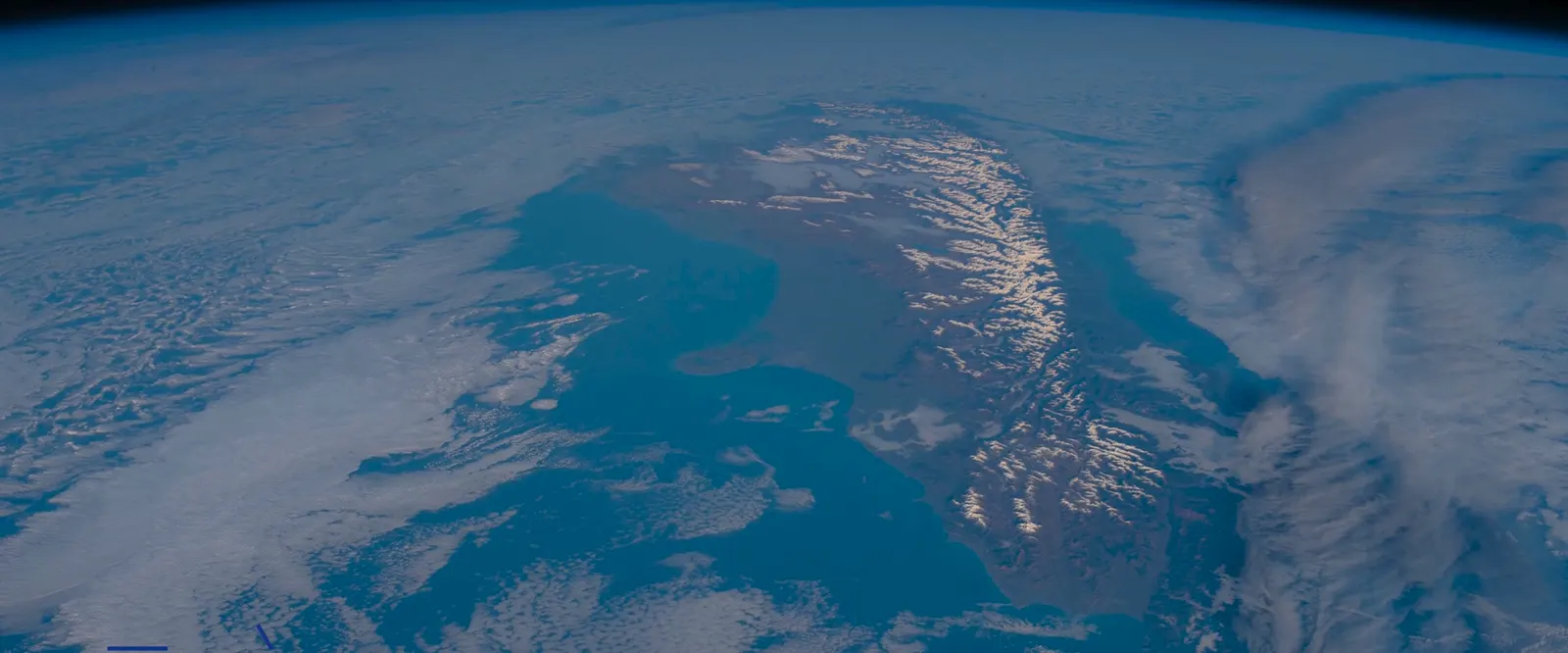 Montanhas nevadas da Nova Zelândia entre nuvens, vistas de cima.